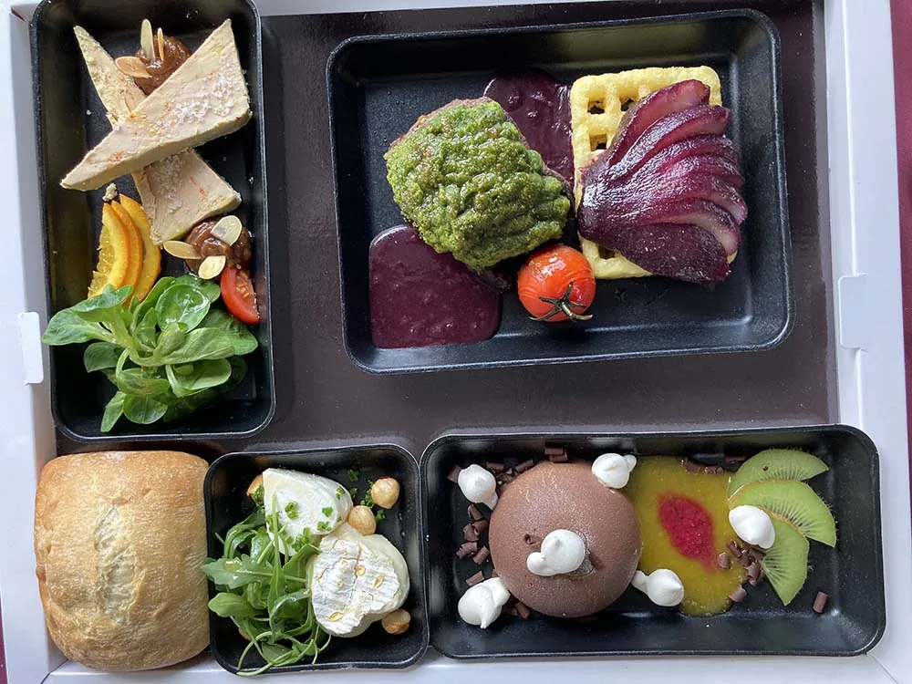 Plateau repas vu du dessus avec son petit pain, son fromage et son dessert