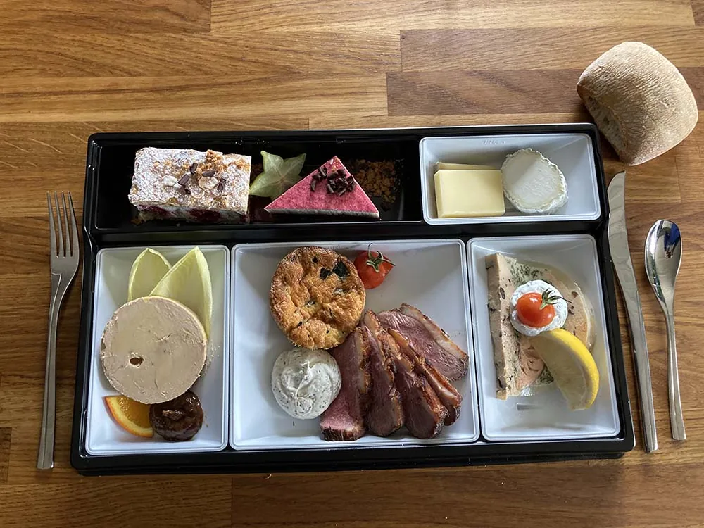 Plateau repas vu du dessus : foie gras, magret, fromages et dessert